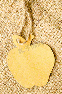大袋背景上的棕色空白标签苹果形状。