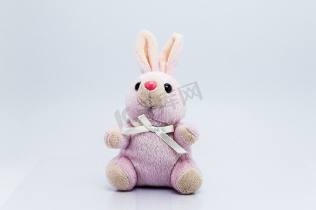 白色兔子摄影照片_孤立在白色背景上的有趣针织兔子玩具