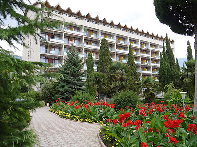 现代大型度假酒店前拥有棕榈种植园和红色美丽大炮的美丽公园