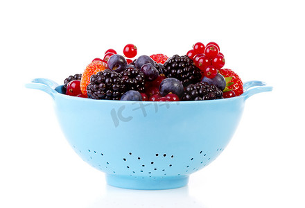 白色背景中带健康新鲜水果的蓝色漏勺