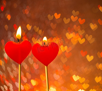 红心蜡烛在温暖的心散景作为背景