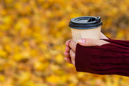 一张舒适温暖的照片，手拿一杯热咖啡