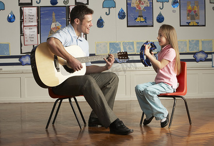 男教师在课堂上与学生弹吉他
