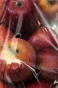 葡萄包装摄影照片_玻璃纸袋中的特写苹果