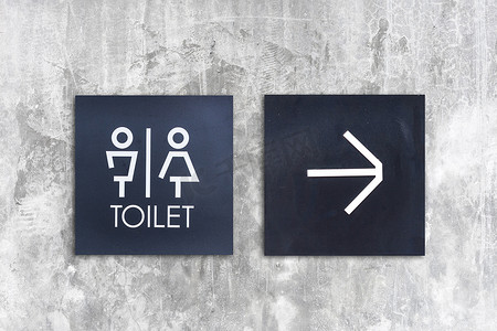 混凝土墙式精品店上的男女通用厕所或厕所和箭头标志