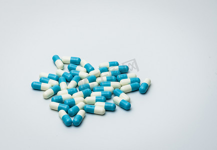 蓝色和白色胶囊药片隔离在白色背景上，带有文本复制空间。
