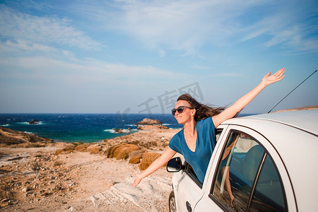 乘汽车度假旅行的年轻女子。