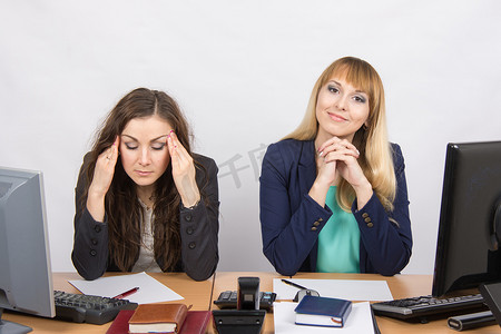 办公室里的情况——照片中一个女孩真的很头疼，另一个看起来很开心
