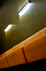 米色沙发摄影照片_深绿色墙壁的房间里有米色沙发和灯光