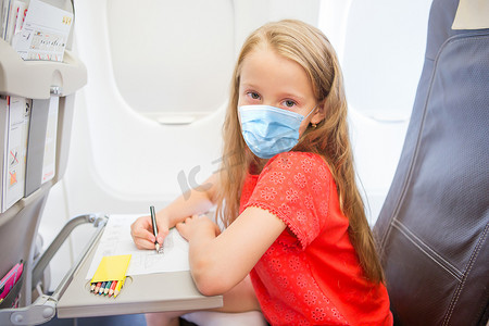 乘飞机旅行摄影照片_可爱的小女孩乘飞机旅行。