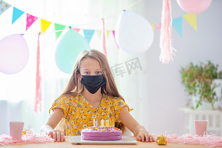 白人女孩梦幻般地微笑着看着生日彩虹蛋糕。