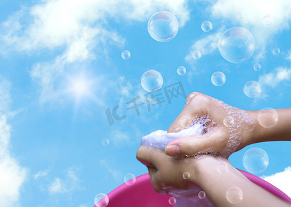干冰泡泡摄影照片_粉红盆中女手洗衣服，泡泡清澈