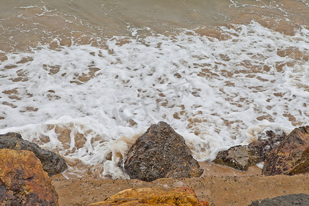 水在海滩岩石周围打旋