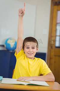 微笑的学生在教室里举手