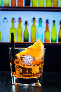 酒吧桌上的一杯 spritz 开胃酒 aperol 鸡尾酒，配橙片和冰块，迪斯科酒廊酒吧氛围背景