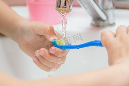 孩子在流水下洗牙刷，特写