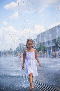 大热天在户外喷泉玩得开心的可爱女孩