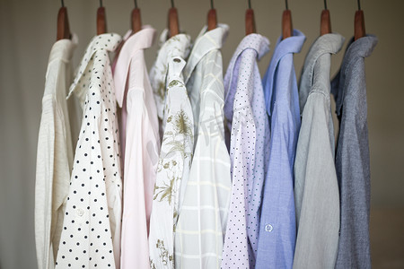 一排各式各样的女式商务衬衫挂在衣架上