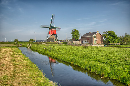 农业风车摄影照片_小孩堤防、荷兰或荷兰的风车和水运河。