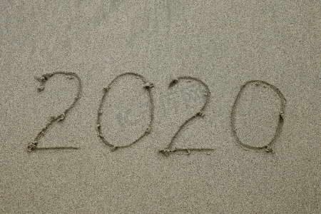 2020 年画在沙滩上，新年概念。