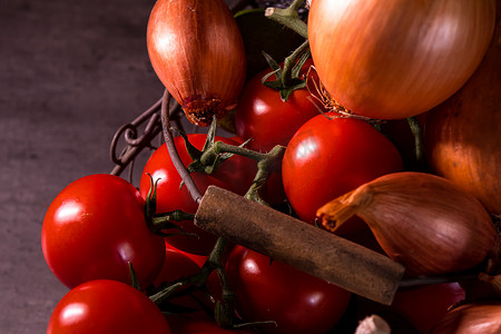 红色蔬菜海报摄影照片_一个旧篮子的海报，上面有洋葱大蒜西红柿来装饰 t