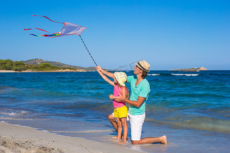 快乐的爸爸和可爱的小女儿一起放风筝