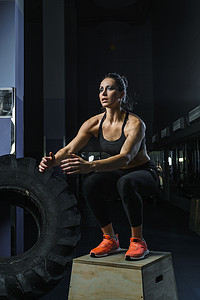 强大的肌肉女 CrossFit 教练在健身房锻炼时跳跃