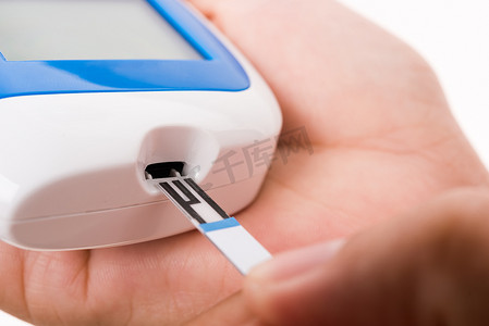 激光血糖仪摄影照片_测量葡萄糖测试水平的妇女用葡萄糖检查手指