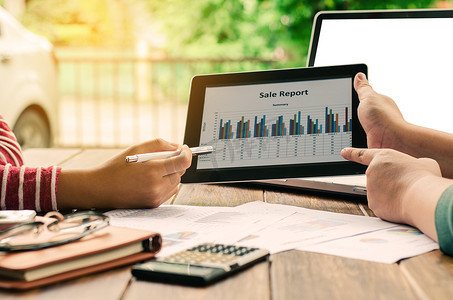 在办公室、工作场所、会议上使用平板电脑中的财务图表进行业务团队分析
