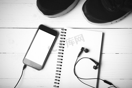 黑白摄影照片_跑步鞋、笔记本和手机黑白色调风格
