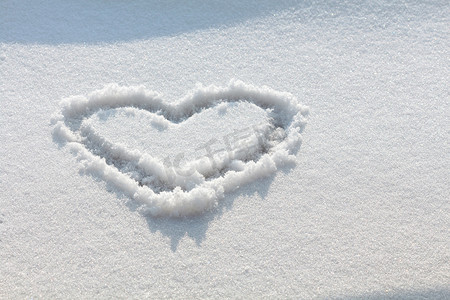 手绘酒桌摄影照片_在雪地里手绘的心