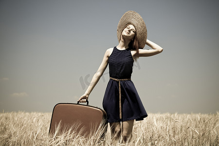 时之魔女摄影照片_带着手提箱的女孩在夏天麦田。