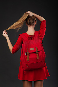一个穿着红色连衣裙、背着红色大背包的女孩的画像