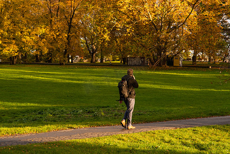 秋季保健摄影照片_2020 年秋季，在布拉格 6 号的莱特纳公园散步时，一名男子正在打电话，当时捷克共和国冬季开始时因 COVID-19 爆发而被隔离