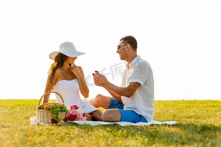带着红色小礼盒在野餐时微笑的情侣