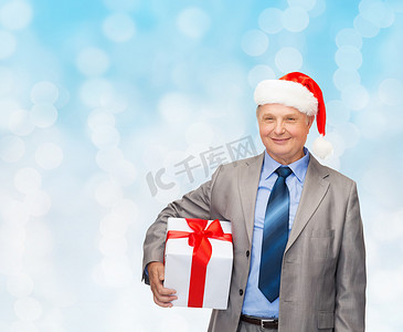 西装摄影照片_穿着西装的微笑男士和带礼物的圣诞老人助手帽