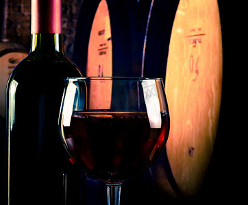旧酒窖背景上靠近瓶子的红酒杯，有文字空间