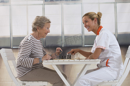 思家摄影照片_在养老院和护士玩耍的老年妇女