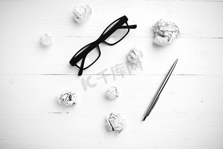 皱巴巴的纸和带钢笔的眼镜 黑白色调