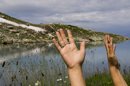 女背面摄影照片_女人手特写湖背景、手和自然。