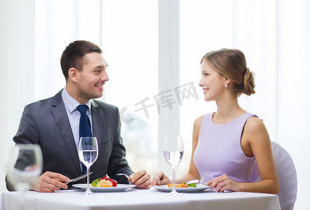 微笑的夫妇在餐厅吃主菜