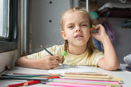 画中的六岁女孩在二等车厢里用铅笔画画