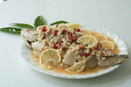 大蒜摄影照片_鲈鱼蒸柠檬、大蒜和红辣椒 — 泰国菜，