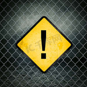 Chainlink 围栏上的感叹号 Grunge 黄色警告标志