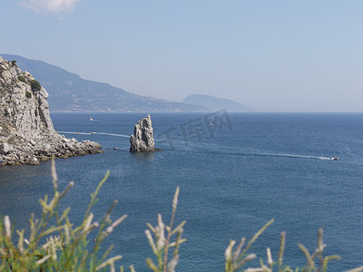 在晴朗的夏日，蓝色大海的美丽景色与漂浮的船只和游艇以及遥远的海岸线。