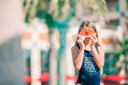 吃女孩西瓜摄影照片_暑假期间在海滩上逗人喜爱的小女孩