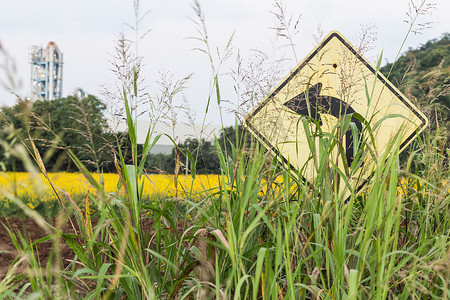 草地覆盖交通标志左转和工厂背景