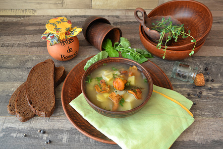 陶瓷碗中的金色鸡油菌蘑菇奶油汤，配新鲜欧芹、芹菜和罗勒。
