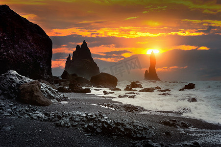 Vik 和玄武岩柱在日落时，冰岛的黑沙滩。