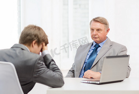 年长的男人和年轻人在办公室发生争执